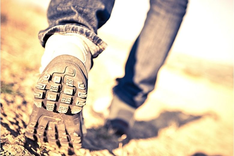 Pair of walking shoes. Back view lower legs and shoe tread